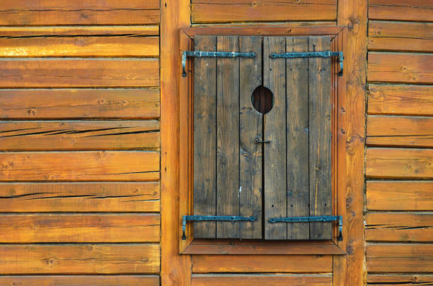 istock Log Wall with Closed Wooden Window Shutters 1134838638
