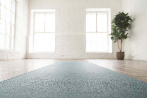 Close up unrolled yoga mat on floor in empty room