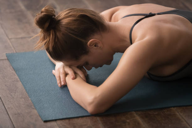 istock Young woman practicing yoga, lying face down, relaxing after training 1134840997