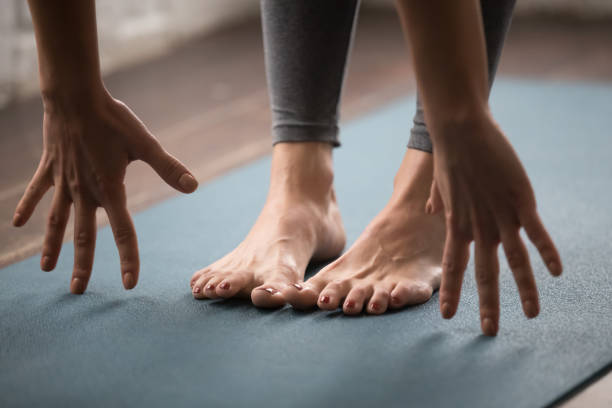 istock Woman practicing yoga, uttanasana pose, Head to knees close up 1134841017