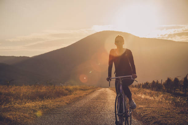 istock Woman cycling in sunset. 1134842667