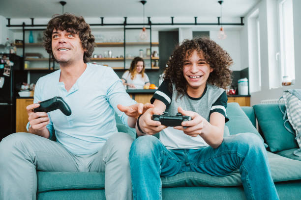 istock Father and son playing digital games at home 1134843635