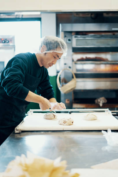 istock Mid adult man preparing bread dough in a commercial kitchen 1134845557
