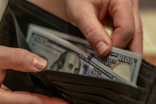 istock Hands holding us dollar bills and small money pouch. 1134847094