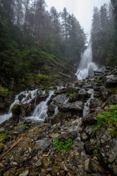 istock fast mountain rocky river in forest with waterfall 1134851193