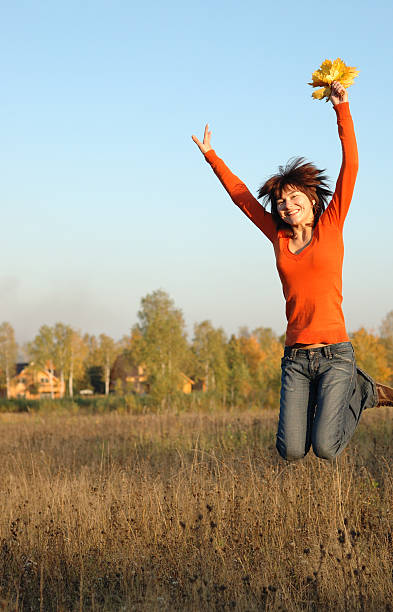 Young woman jumping in field stock photo