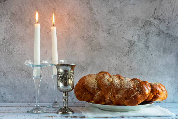 Shabbat Shalom - challah bread, shabbat wine and candles on wooden table Shabbat Shalom - challah bread, shabbat wine and candles on wooden table. jewish sabbath photos stock pictures, royalty-free photos & images