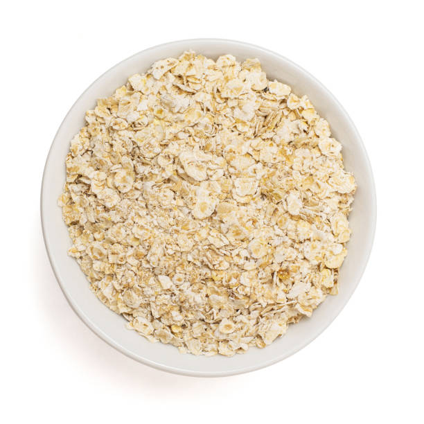 istock Dry rolled oatmeal in bowl isolated on white background. Top view 1134856187
