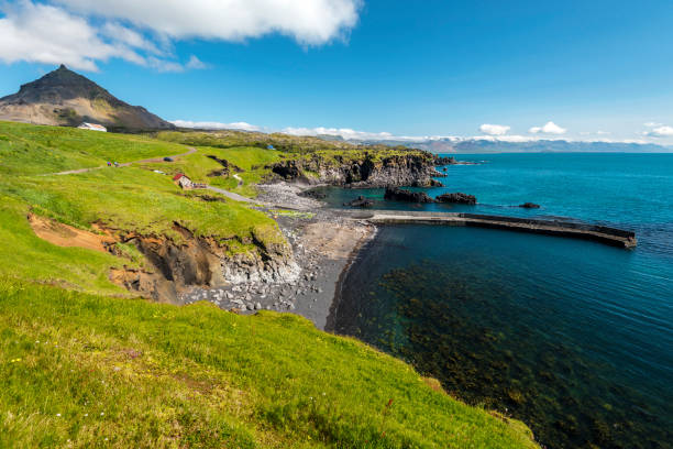 istock View at Hellnar and Valasnos cliffs on Snaefellsnes peninsula in Western Iceland. Basalt rocks and concrete pier and islets are washed by blue Ocean water. 1134858738