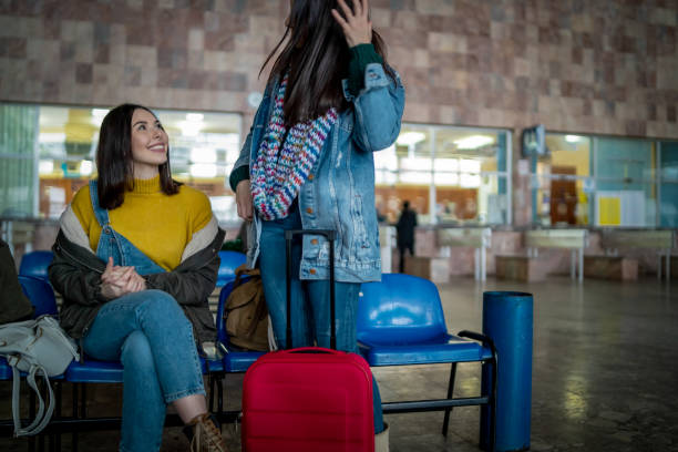 istock Two friends talking and waiting train in railway station 1134859837