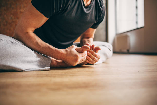 istock Young man doing yoga in big bright training gym 1134862716