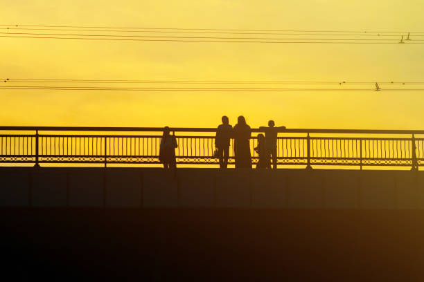 istock Silhouettes a Group of People on the High Bridge 1134862803
