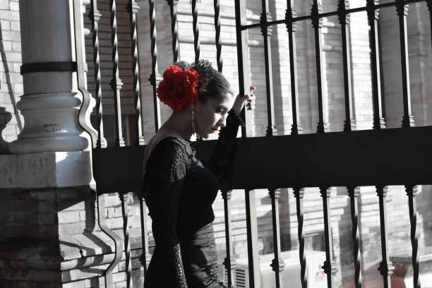 die melancholische frau im flamenco-kleid, mit der roten blume im haar - malaga seville cadiz andalusia stock-fotos und bilder