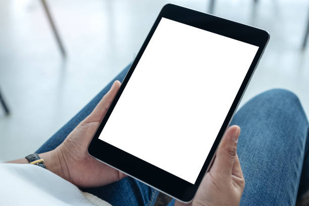 istock Mockup image of a woman holding black tablet pc with blank white screen while sitting in cafe 1134867536