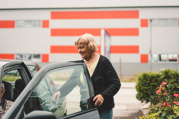 istock Senior woman opens car doors for man 1134868844