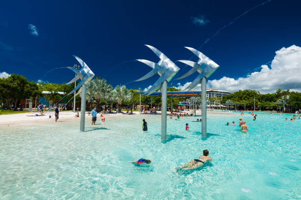 cairns, australia-27 de marzo de 2016. laguna de natación tropical en la explanada en cairns con playa artificial, queensland, australia. - cairns fotografías e imágenes de stock