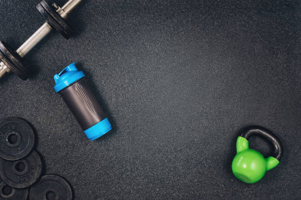 Fitness or bodybuilding background. Dumbbells on gym floor, top view Fitness or bodybuilding concept background. Product photograph of old iron dumbbells on black grey, conrete floor in the gym. Photograph taken from above, top view with lots of copy space weight photos stock pictures, royalty-free photos & images