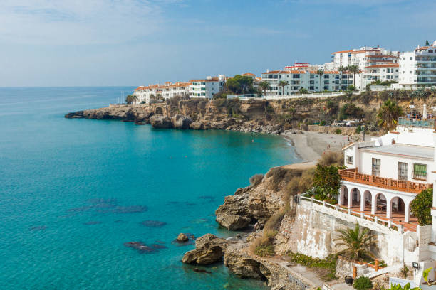 view from balcony de europe, nerja, at the costa del sol. Beautiful sunny day in andalusia. view down to the costa del sol, near nerja, a town in andalusia in the summer season. Beach, sea and the typical white buildings of the tihs part of spain in the background. nerja stock pictures, royalty-free photos & images