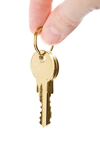 istock fingers holding golden keys isolated 113487478