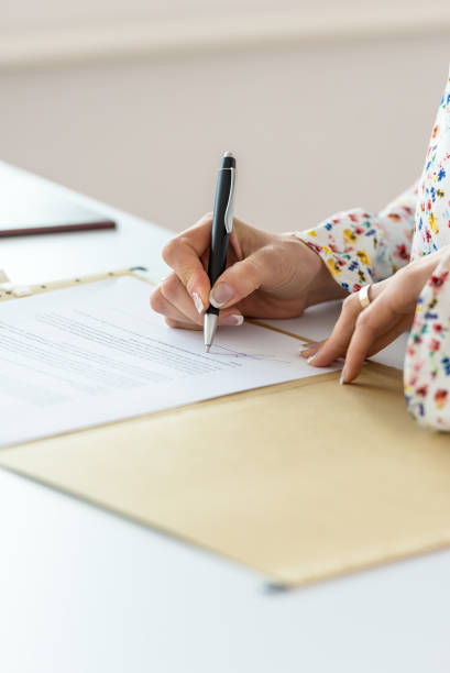 Closeup of businesswoman signing contract stock photo