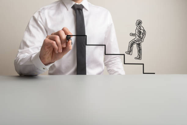 istock Business executive drawing steps for a hand drawn businessman to climb 1134883901