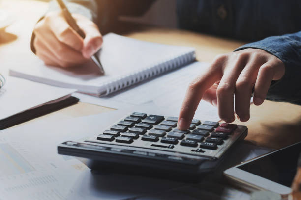 istock business woman working on desk with using calculator 1134883976