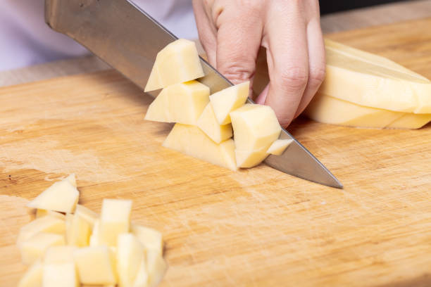 istock cook cuts potatoes on a wooden board 1134884251