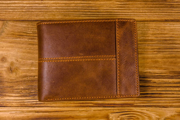 istock Closed brown leather wallet on wooden table. Top view 1134884906
