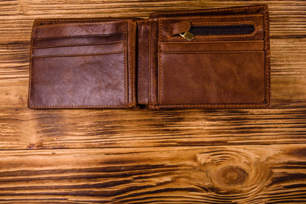 istock Opened brown leather wallet on wooden table. Top view 1134884907