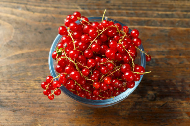 istock red currants on a brown wooden table in a plate. 1134886572