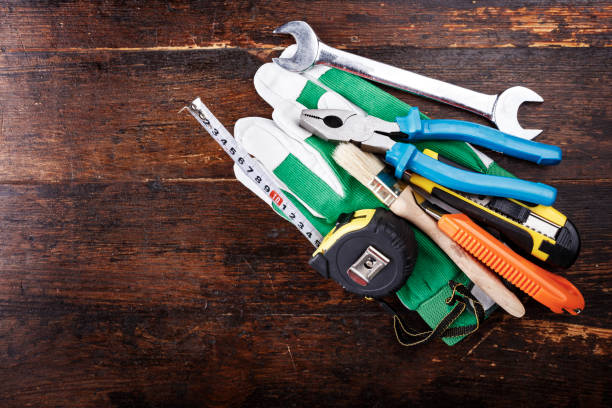 istock Work gloves and carpenter tools lie on a brown wooden table. view from above. 1134888863