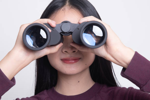 istock Young Asian woman with binoculars. 1134889116