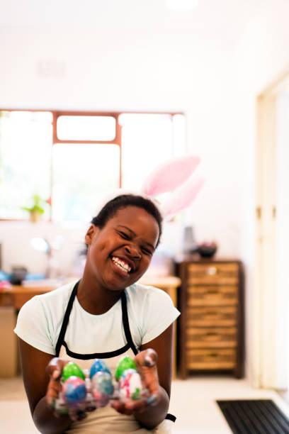 Happy young African girl showing her hand painted Easter eggs to camera