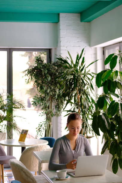 istock The girl works at the computer in a cafe 1134895336