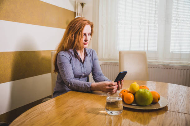 istock Mid age woman using mobile phone at home 1134897014