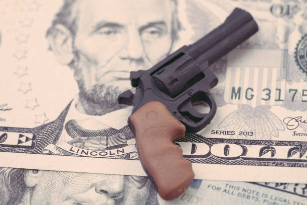 big money in gun industry, gun control policy in united state of america concept, mass shooting protection, miniature toy guns on us dallar bill - police crime gun gang member imagens e fotografias de stock