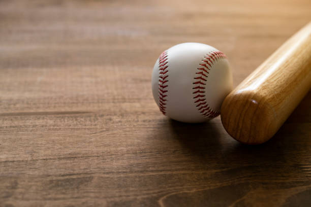 istock baseball and baseball bat on wooden table background, close up 1134898406