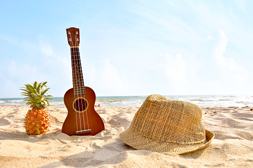 The Summer day with Guitar ukulele for relax on the beautiful beach and blue sky background