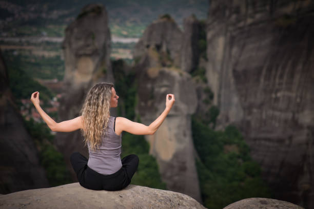 istock Woman meditating at Meteora,Greece 1134905137