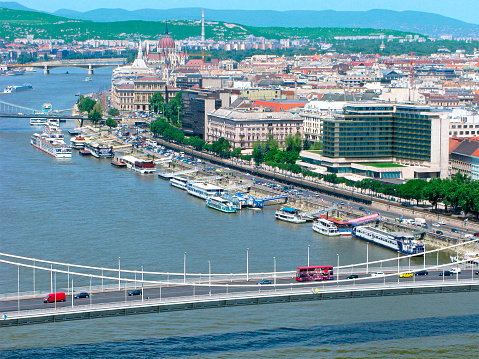 Budapest, Hungary. Panorama of the city from the Gellert Hill: Danube river, Elisabeth bridge, Hungarian Parliament, buildings, green hills, piers with ships.