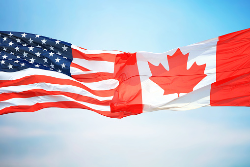 Flag of Canada and the USA against the background of the blue sky