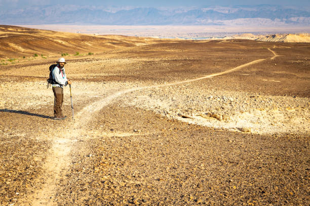 istock Backpacker tourist walking desert trail  landscape. 1134908750