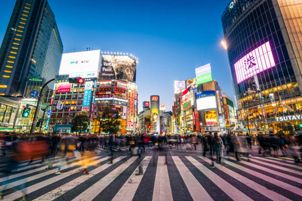 Pedestrians crossing the street at Shibuya crossing with motion blur pedestrians walking across with crowded traffic at Shibuya crossing square.Shibuya crossing is the busiest road crossing in the world. Shibuya, Tokyo, Japan, tokyo prefecture stock pictures, royalty-free photos & images