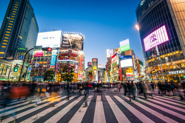 пешеходы, переходя улицы на перекрестке сибуя с размытием движения - japan стоковые фото и изображения