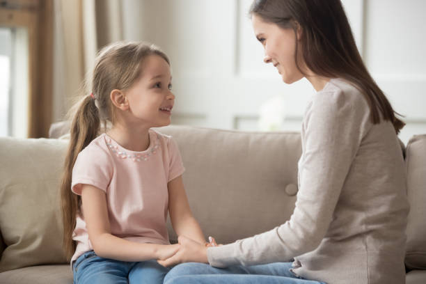 愛情の母と子供の手を持っているソファの上に座って話す - child discussion parent talking ストックフォトと画像