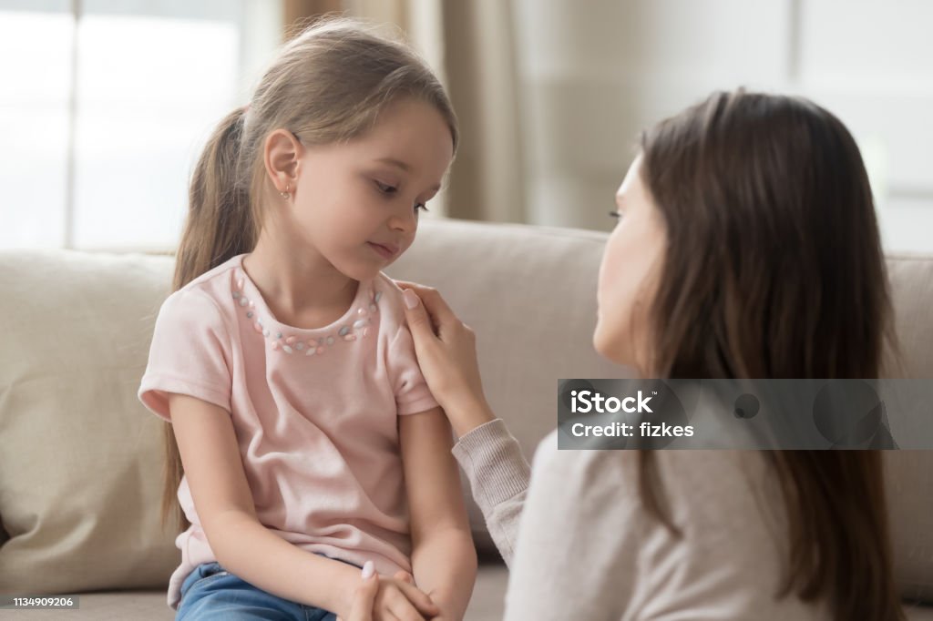 Loving mom talking to upset little child girl giving support Loving worried mom psychologist consoling counseling talking to upset little child girl showing care give love support, single parent mother comforting sad small sullen kid daughter feeling offended Child Stock Photo
