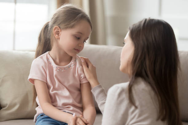 Loving mom talking to upset little child girl giving support Loving worried mom psychologist consoling counseling talking to upset little child girl showing care give love support, single parent mother comforting sad small sullen kid daughter feeling offended one kid only stock pictures, royalty-free photos & images