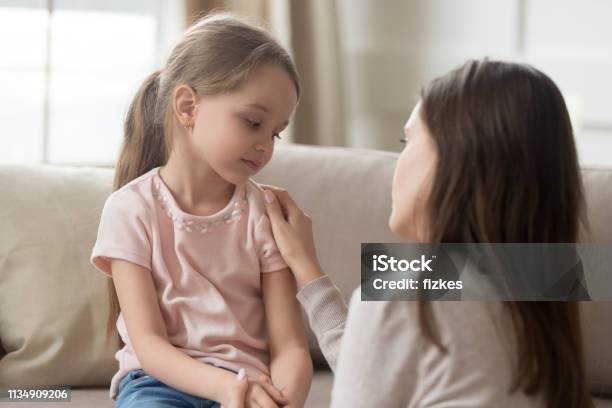 Loving Mom Talking To Upset Little Child Girl Giving Support Stock Photo - Download Image Now