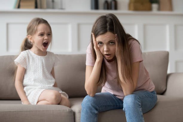 stressé mère sentiment désespérée au sujet de crier têtu enfant fille colère - piquer une colère photos et images de collection