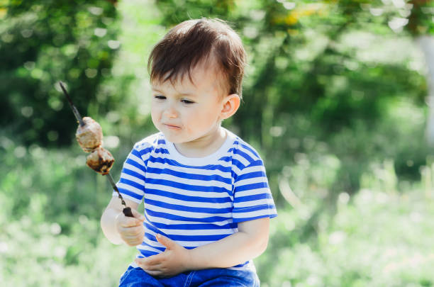 istock Little Boy Eating Kebab on a Skewer 1134909997